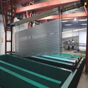 Anodizing process on Aluminum Extrusion Profiles showing profiles suspended on racks being lowered into electrolytic tanks for durable oxide layer formation, enhanced corrosion resistance and aesthetic finish in Building Materials and Construction applications