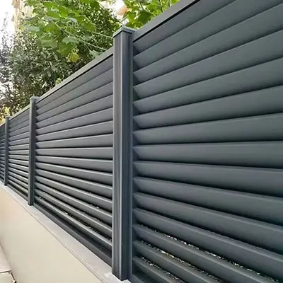 Modern dark gray aluminum fence and railing systems with horizontal slats installed outdoors next to greenery, showcasing Fence & Railing Systems applications of Aluminum Extrusion Profiles in durable perimeter fencing, safety barriers and residential/commercial railings