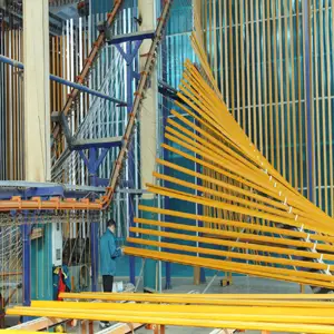 Powder coating process on Aluminum Extrusion Profiles in factory showing electrostatic powder application and bright yellow finished profiles for durable, weather-resistant surface treatment in Building Materials, Construction and Industrial applications