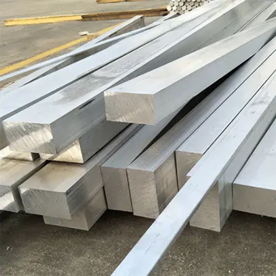 Solid square aluminum bars piled on factory floor, high-quality material by Yoverd Aluminium suitable for structural, machining and industrial applications
