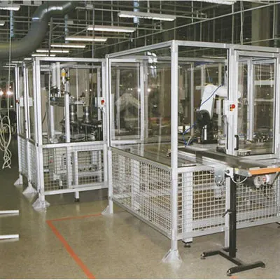 Realistic industrial setting with aluminum extrusion profiles forming safety fence and machine guarding partitions around robotic equipment and production lines for enhanced worker protection and area separation by Yoverd Aluminium.