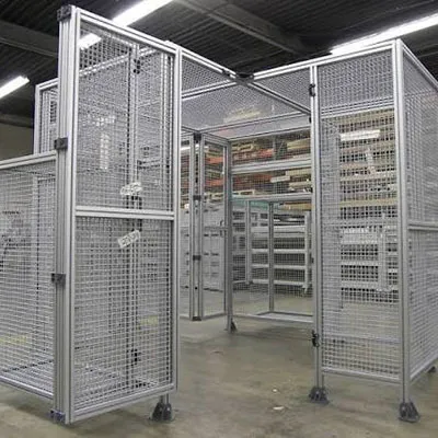 Durable aluminum extrusion profiles forming modular safety fence enclosures with mesh panels and access doors in a warehouse setting for secure industrial area separation and protection by Yoverd Aluminium.