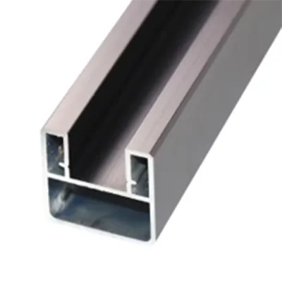 Close-up of a silver brushed aluminum railing extrusion profile featuring multiple internal channels and a hollow rectangular section, engineered for strength in commercial and public infrastructure by Yoverd Aluminium.